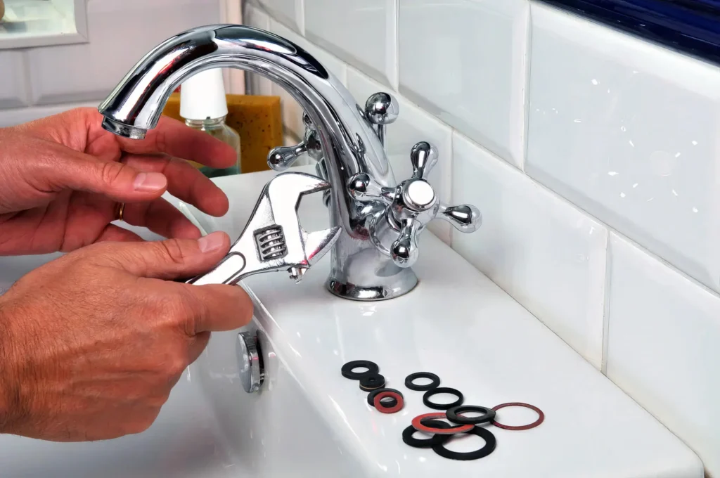 Plumber performing maintenance on a bathroom faucet in Brandon