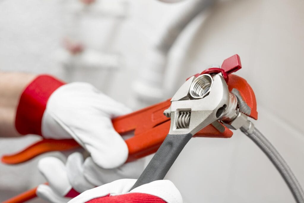 Plumber holding pipe wrenches for an emergency repair in Brandon