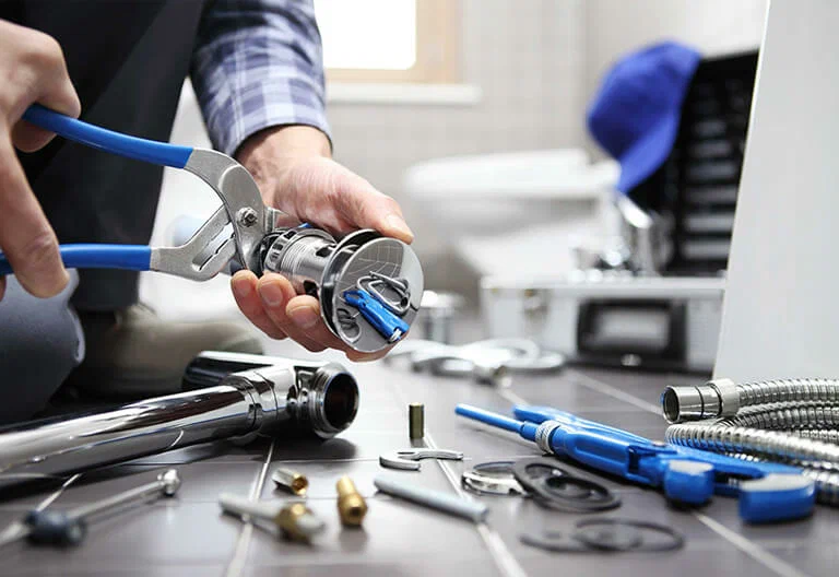 Technician repairing a plumbing fixture with professional tools in Brandon