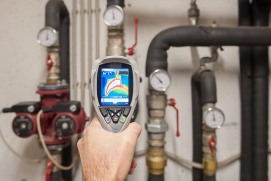 Plumber using a thermal imaging camera to inspect pipes in Brandon