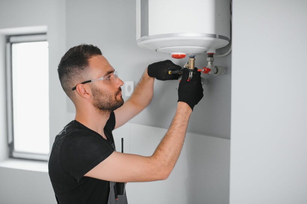 Technician performing water heater maintenance in Brandon