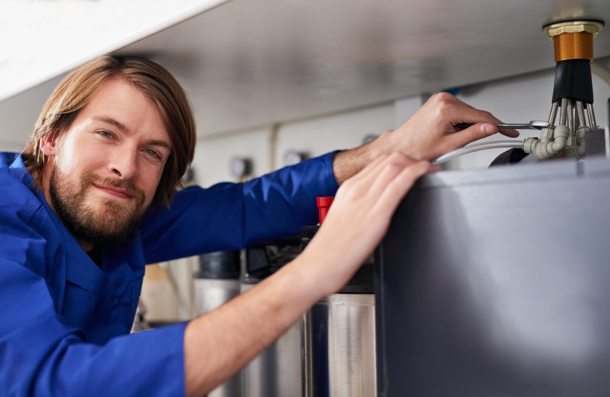 Technician servicing a residential water heater tank in Brandon