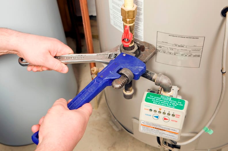 Plumber repairing a water heater valve in Brandon